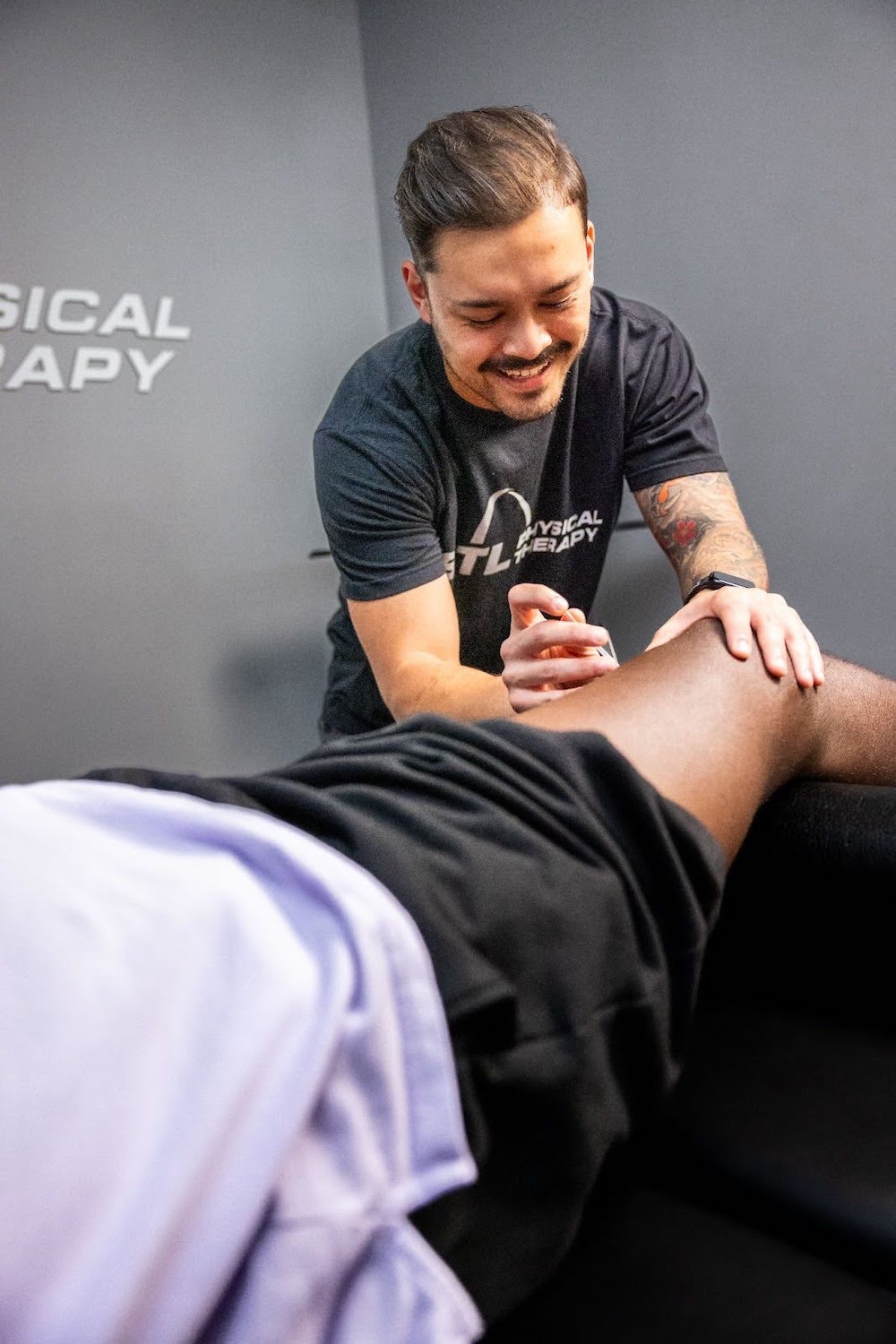 Physical therapist treating a patient on a table, dry needling in St. Louis at STL Physical Therapy
